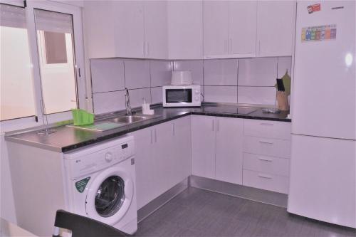 a white kitchen with a washing machine in it at Urban Flat in Santa Cruz de Tenerife