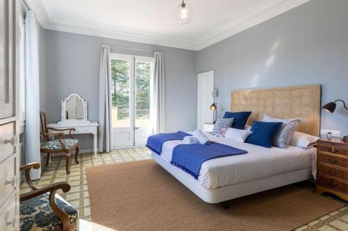 a bedroom with a bed and a desk and a window at La Torre del Dr. Pont. Nature and entertainment. in Sant Boi de Lluçanès