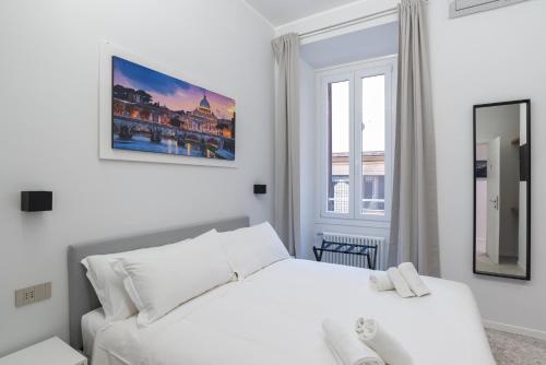 een witte slaapkamer met een wit bed en een raam bij White Home Suite and Rooms in Rome