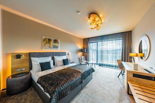Habitación de hotel con cama y escritorio en Maximus Resort en Brno