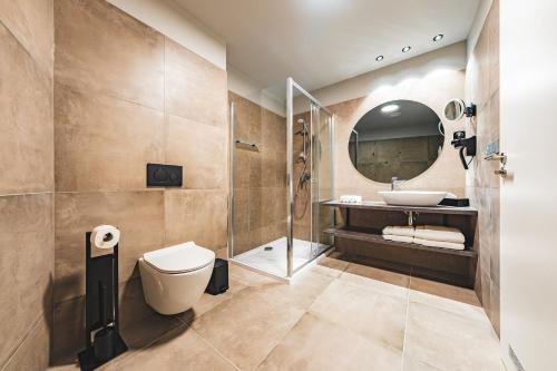 a bathroom with a toilet and a sink and a shower at Maximus Resort in Brno