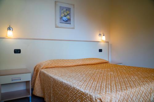 トルトレート・リドにあるResidence Il Borgoのベッドルーム1室(ベッド1台、壁に照明2つ付)