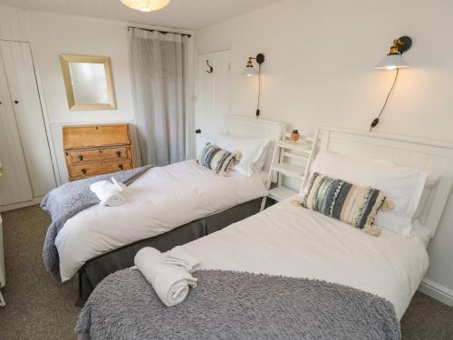 two beds in a room with white walls at 1 Tulse Hill Cottages in Ventnor