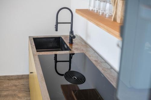 a kitchen counter with a sink with a hose at Altstadtloft in Bad Tölz