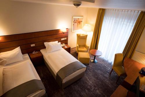 a hotel room with two beds and a window at Hotel Fulda Mitte in Fulda