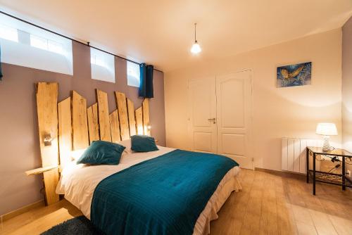 een slaapkamer met een groot bed met blauwe lakens bij groupe arbane-chardonnay in Buchères
