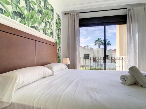 una camera da letto con un grande letto con una grande finestra di Roda Golf Singapore Apartment - 8109 a Roda