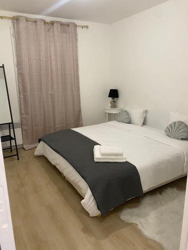 - une chambre avec un lit et une couverture noire et blanche dans l'établissement appartement luxueux 70m2, 2 chambres, à Argenteuil