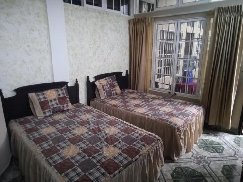a hotel room with two beds and a window at Hotel Casa de Don Francisco in Flores