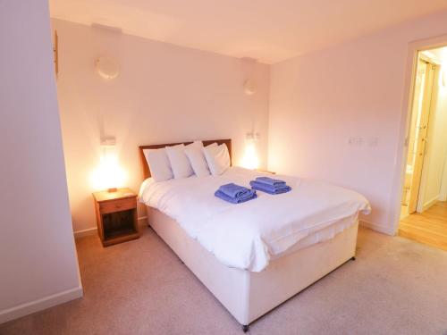 a bedroom with a white bed with two towels on it at Tides Reach in Newton Stewart