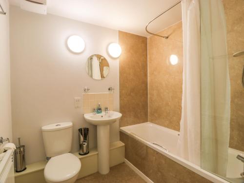 a bathroom with a toilet and a sink and a tub at Tides Reach in Newton Stewart