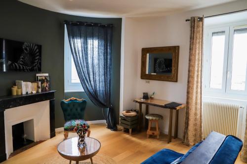 ein Wohnzimmer mit einer blauen Couch und einem Kamin in der Unterkunft C’est l’app’Art! Pau centre in Pau