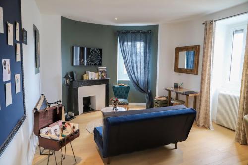 un salon avec un canapé bleu et une cheminée dans l'établissement C’est l’app’Art! Pau centre, à Pau