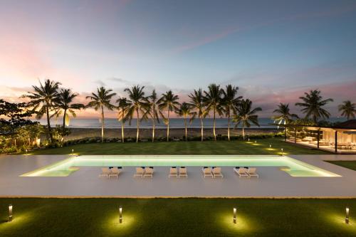 - une vue sur la piscine avec des chaises et l'océan dans l'établissement Saba Estate Luxury Villa Bali, à Saba