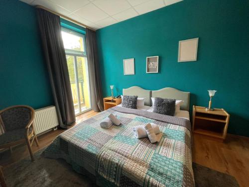 a blue bedroom with a bed with two pillows on it at Parkhotel Waldschlösschen in Annaberg-Buchholz