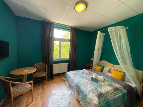 a bedroom with a bed and a table and a window at Parkhotel Waldschlösschen in Annaberg-Buchholz