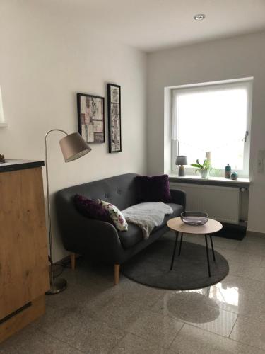 a living room with a couch and a table at Ferienwohnung am Pferdemarkt in Konz