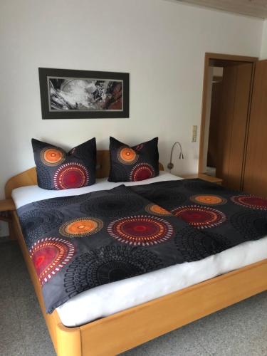 a bedroom with a bed with a black comforter and pillows at Ferienwohnung am Pferdemarkt in Konz
