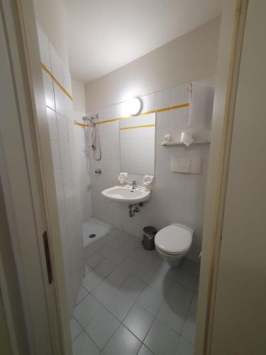 a bathroom with a white toilet and a sink at Hotel Cumilì in Capo di Ponte