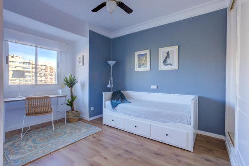 een slaapkamer met een wit bed en blauwe muren bij Valencia-live in Valencia