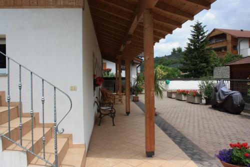 a patio with stairs and a wooden roof at Kampflhof Apartments in Schenna