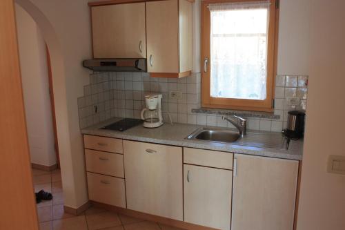 una pequeña cocina con fregadero y ventana en Kampflhof Apartments, en Scena