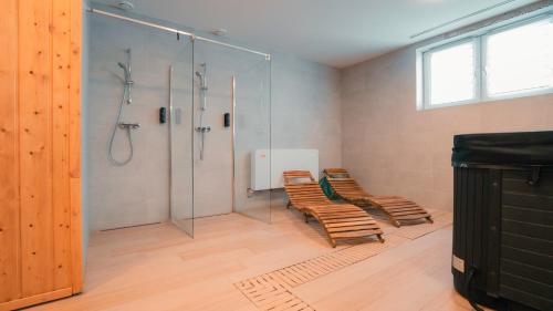 a bathroom with two chairs and a glass shower at Apartmán 101 Vila Zuberec in Zuberec