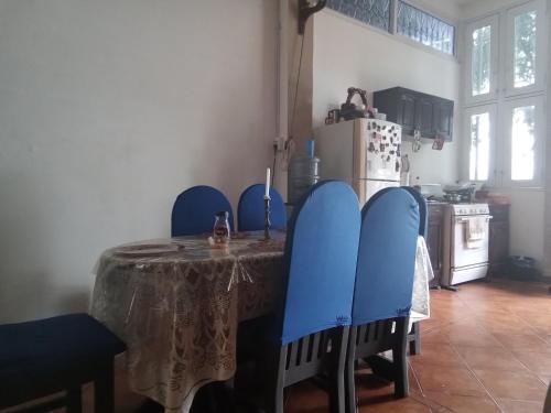 a kitchen with a table with blue chairs and a refrigerator at Hotel Casa de Don Francisco in Flores