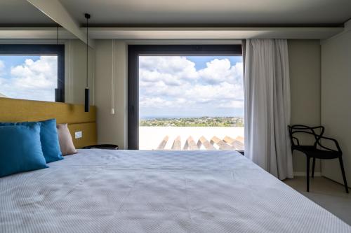 um quarto com uma cama grande e uma janela grande em Villa vista mare Piscina e SPA em Castellammare del Golfo