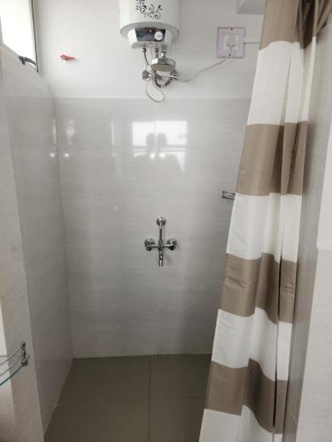 baño con ducha con una cruz en la pared en Bedz, en Āīzawl