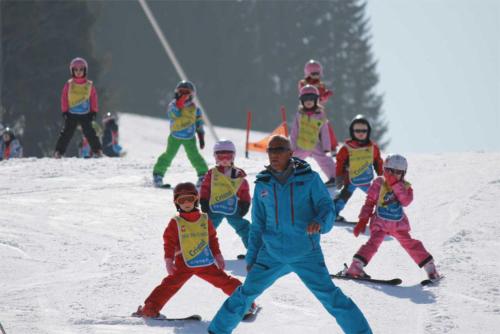 a man and a group of children on a ski slope at Chalet Aventure B&B Les Gets in Les Gets
