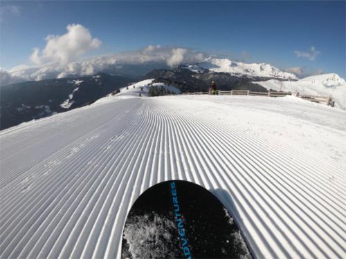 a person riding a snowboard down a snow covered slope at Chalet Aventure B&B Les Gets in Les Gets