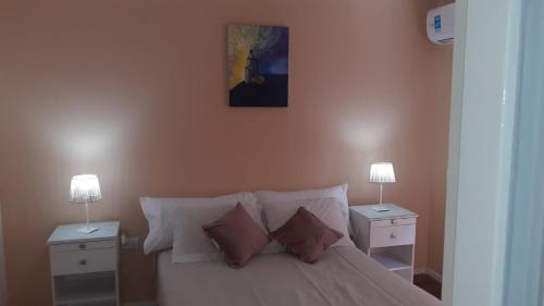 1 dormitorio con 1 cama blanca y 2 mesitas de noche en Departamento en el centro de Mendoza en Mendoza