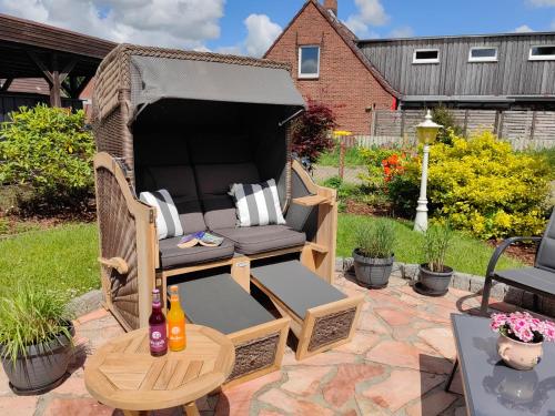 a wicker chair and table on a patio at Gästehaus Arkona in Tönning