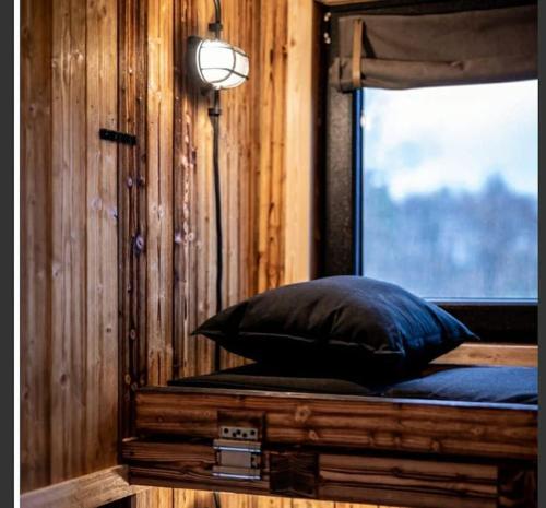 a room with a bed with a window and a pillow at Tiny House Calido in Apelern