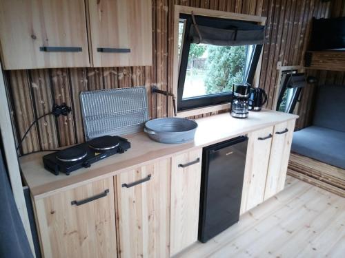 eine Küche mit Holzschränken und einem Fenster in einem Wohnwagen in der Unterkunft Tiny House Calido in Apelern
