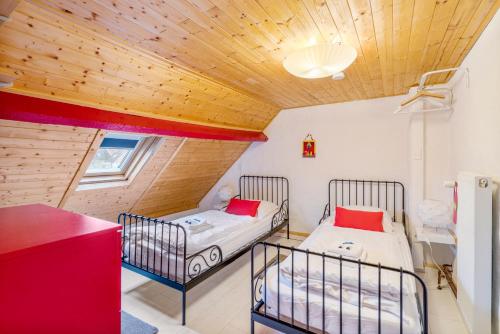 two beds in a room with a wooden ceiling at Ruime gezinswoning nabij historisch centrum tot 6p mét terras in Bruges