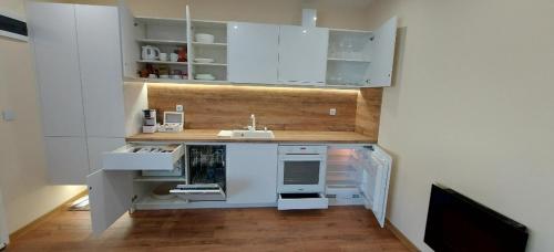 una cocina con armarios blancos y fregadero en Релакс Хисаря 2, en Hisarya