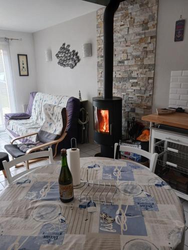 un salon avec une table avec une bouteille de vin dans l'établissement Maison proche de l ocean, à Saint-Gildas-de-Rhuys