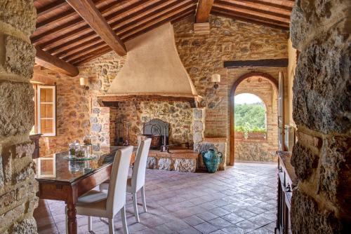 a kitchen with a table and a stone wall at Antica Dimora in San Gimignano