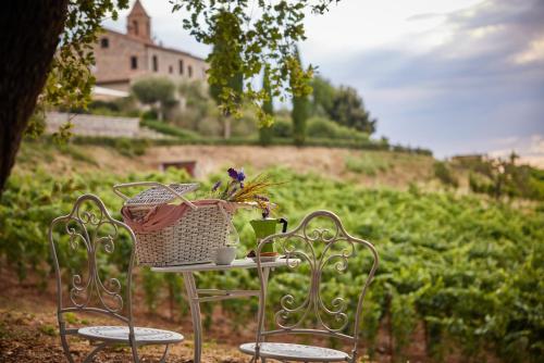 a table with a basket of flowers and two chairs at Antica Dimora in San Gimignano