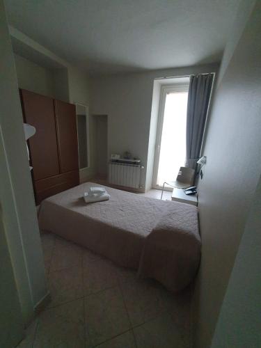 a small bedroom with a bed and a window at Hotel Cumilì in Capo di Ponte