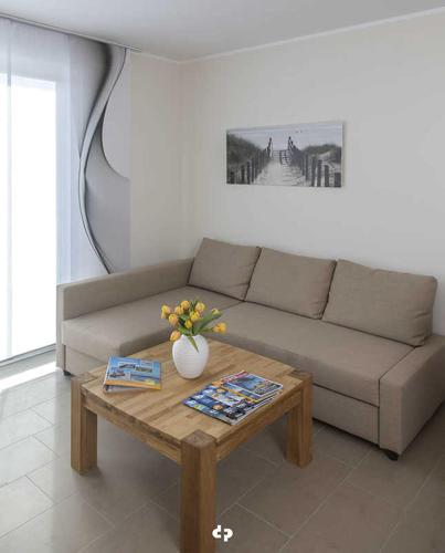 een woonkamer met een bank en een salontafel bij DUENENZEIT App Nr 5 max 4 Pers in Dierhagen