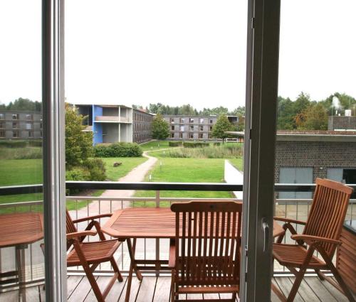 een patio met een tafel en stoelen op een balkon bij DUENENZEIT App Nr 5 max 4 Pers in Dierhagen