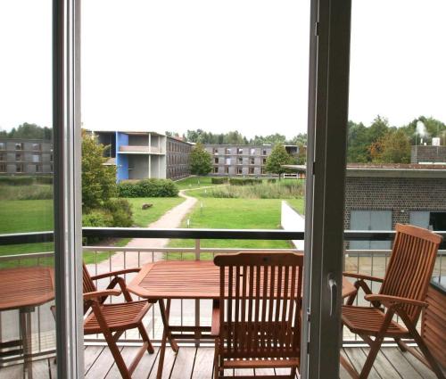 a patio with a table and chairs on a balcony at DUENENZEIT App Nr 5 max 4 Pers in Dierhagen