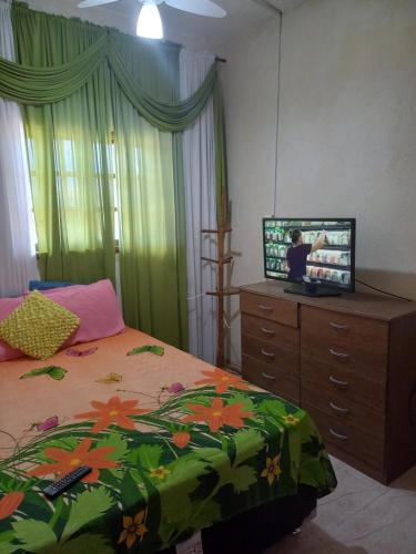 1 dormitorio con cama y vestidor con TV en Familia Porto, en Arraial do Cabo