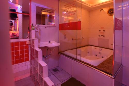 un bagno con vasca e lavandino di Motel Kaskata a Santa Cruz do Sul