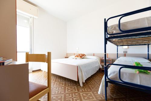 a bedroom with two bunk beds and a window at Residence Rainbow in Bellaria-Igea Marina