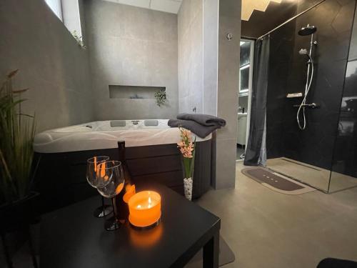 a bathroom with a tub and a table with candles at TEPIĆ Garni Hotel in Temerin
