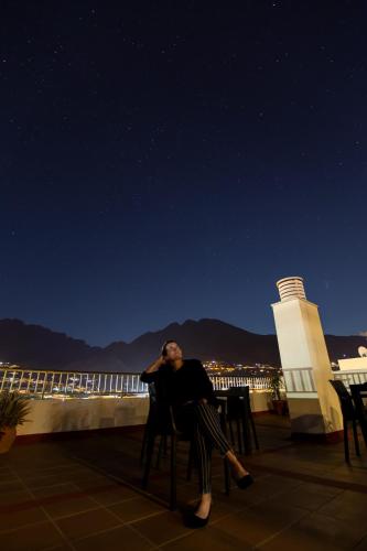 a man sitting in a chair on a balcony at night at Hotel Valle Aridane in Los Llanos de Aridane